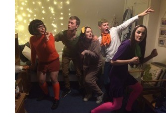 A group of students dressed as Scooby Doo characters, acting frightened.