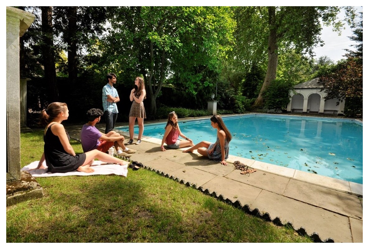Students sitting by pool
