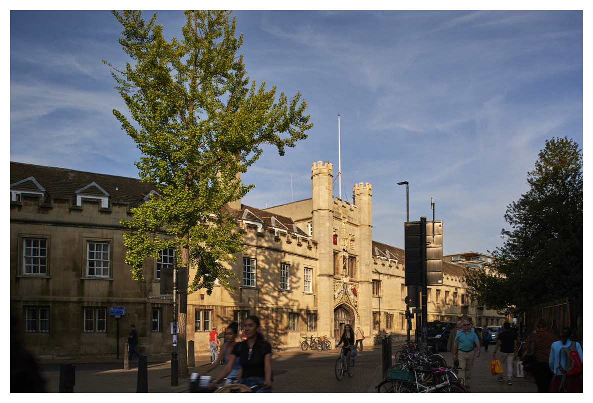 Front of College with cyclists going past