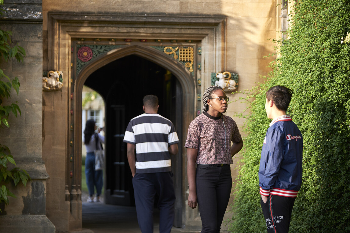 Students talking in front of arch through to second court