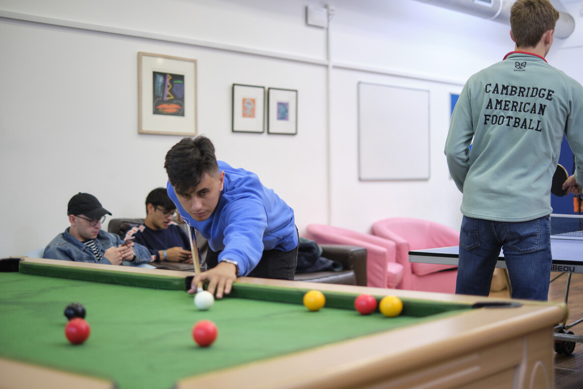 male student playing pool