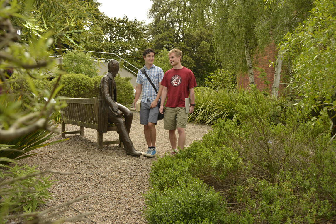 Two males walking through the Darwin garden