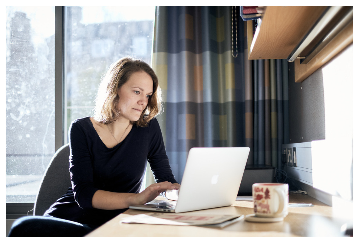 Female student sat at a desk and using a laptop