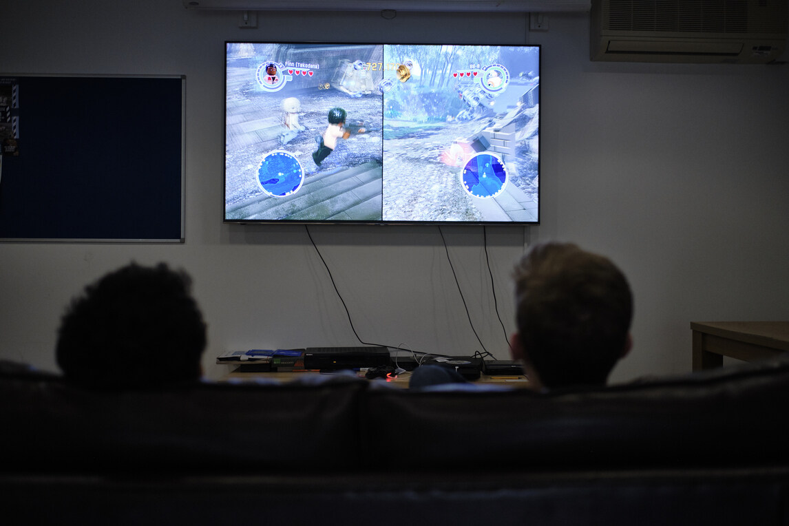 Students playing computer games in darkened room