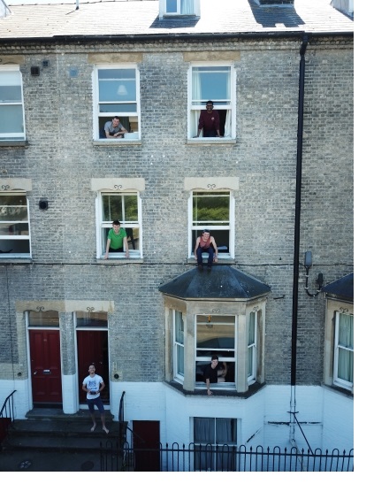 Rory and his housemates looking out of the street-facing windows of two houses owned by Christ's College on Jesus Lane.