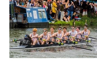 A rowing boat mid-race, during Bumps on the river Cam.