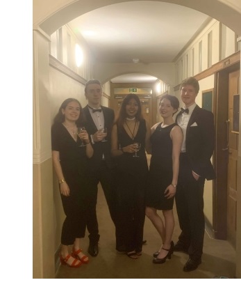 A group of students in black tie stood in a corridor