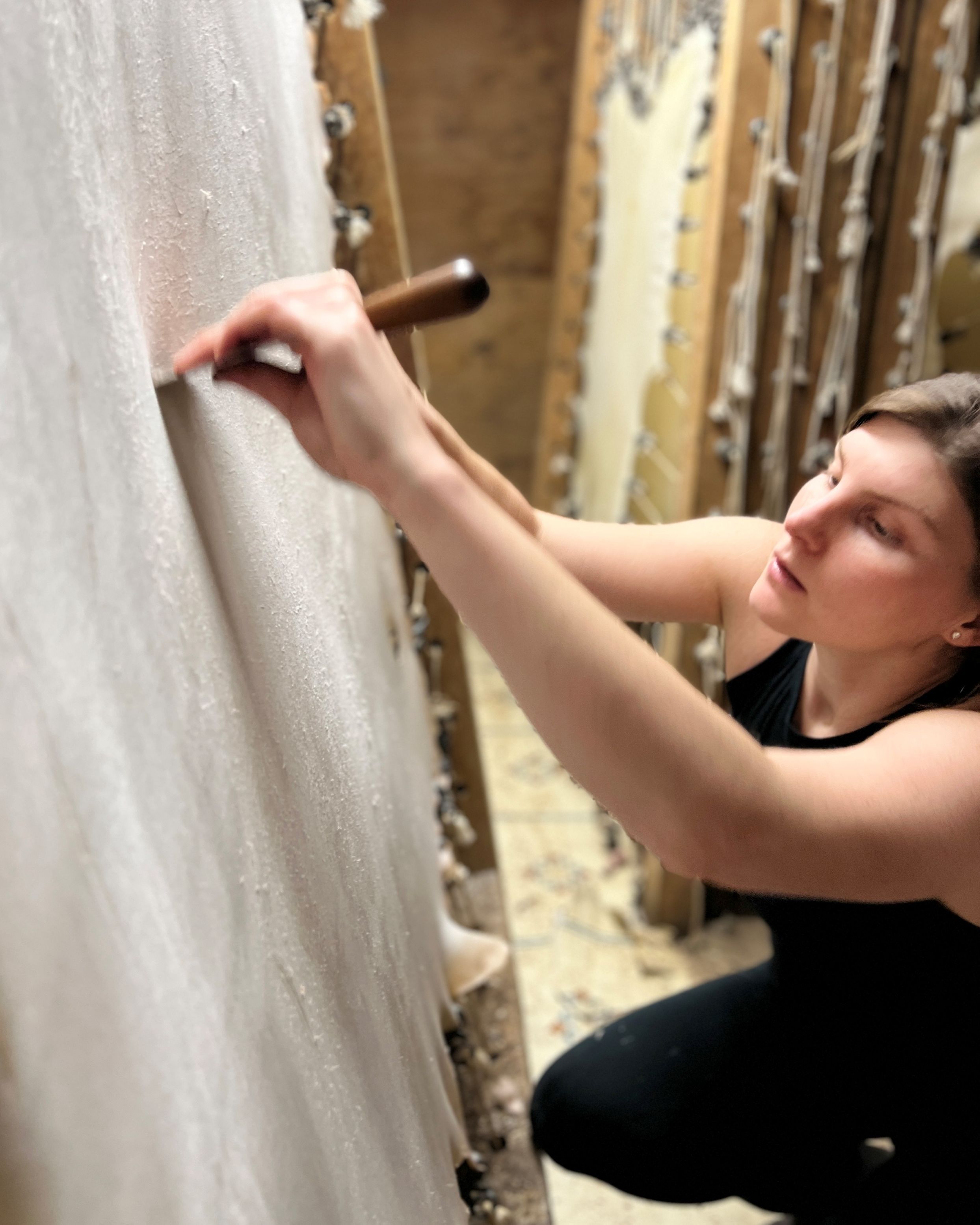 Person scraping vellum in a workshop