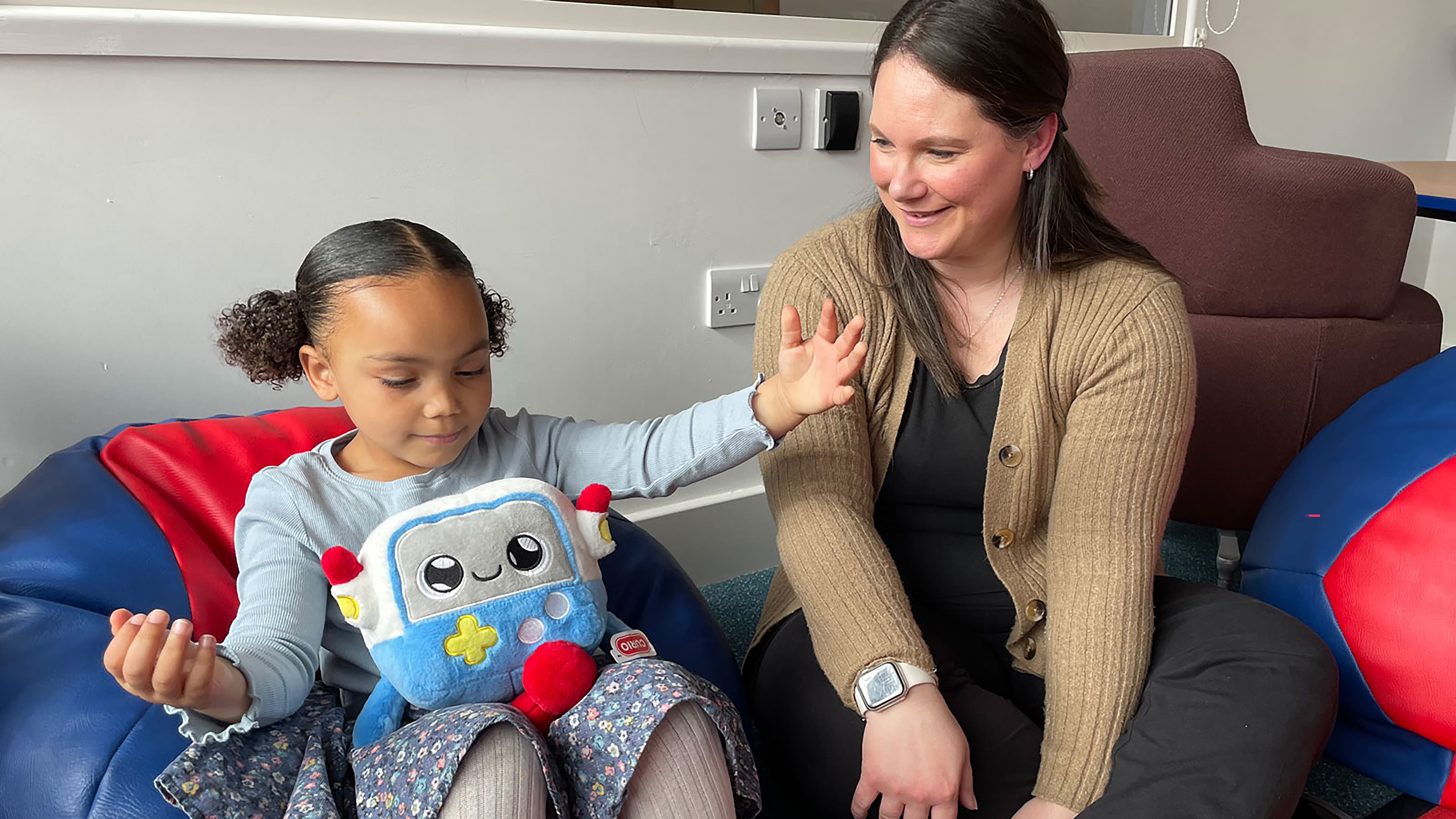 Carer and child playing with an AI toy