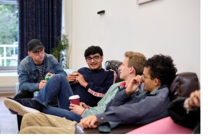 Four male students sat on a sofa chatting in the JCR (Junior Common Room) of Christ's College, Cambridge.