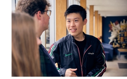 Students chatting in the main corridor of the library at Christ's College, Cambridge.