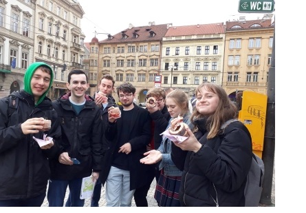 A group of young people with chimney cakes, in Prague.