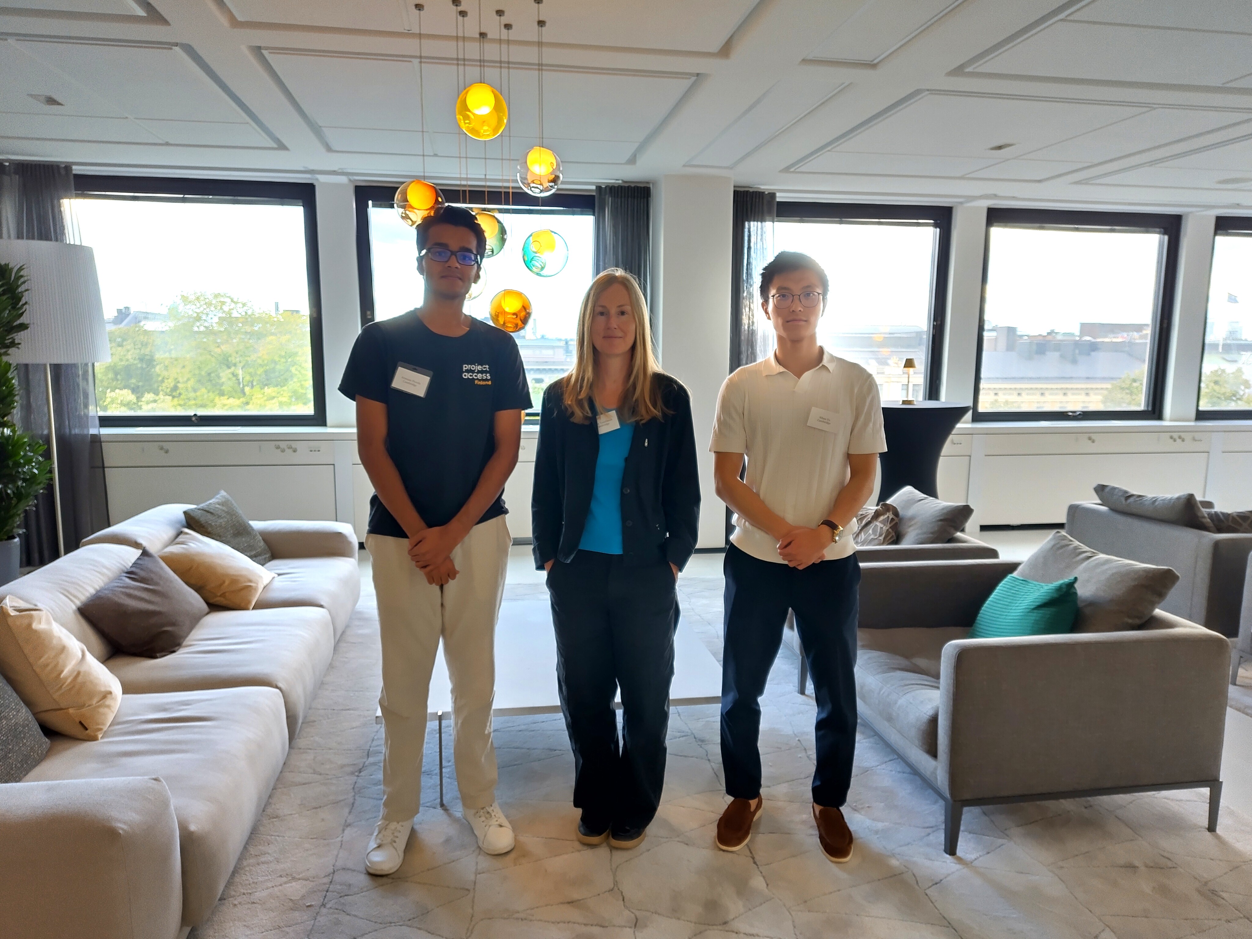 Emily Tomlinson and two others standing in front of a window with sofas to either side