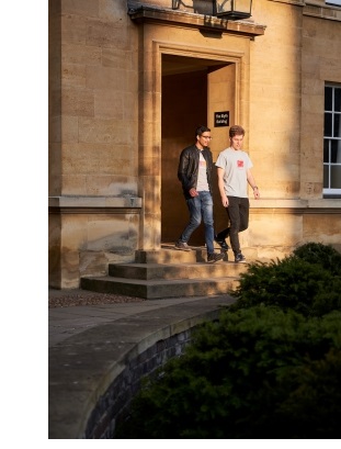 Two male students leaving the Blyth building in Third Court at Christ's College, Cambridge.