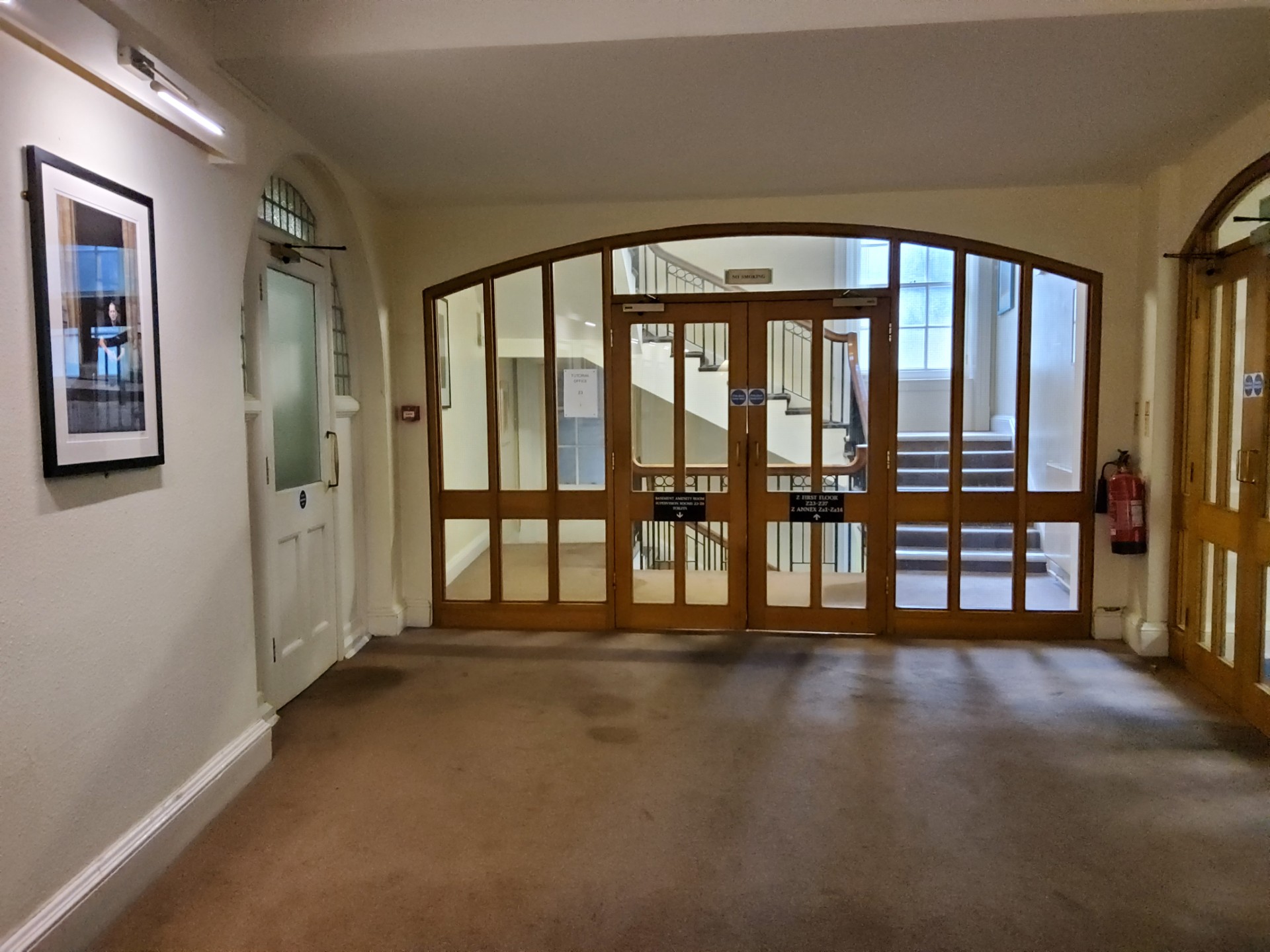 Stairs through the double doors at the end of the corridor