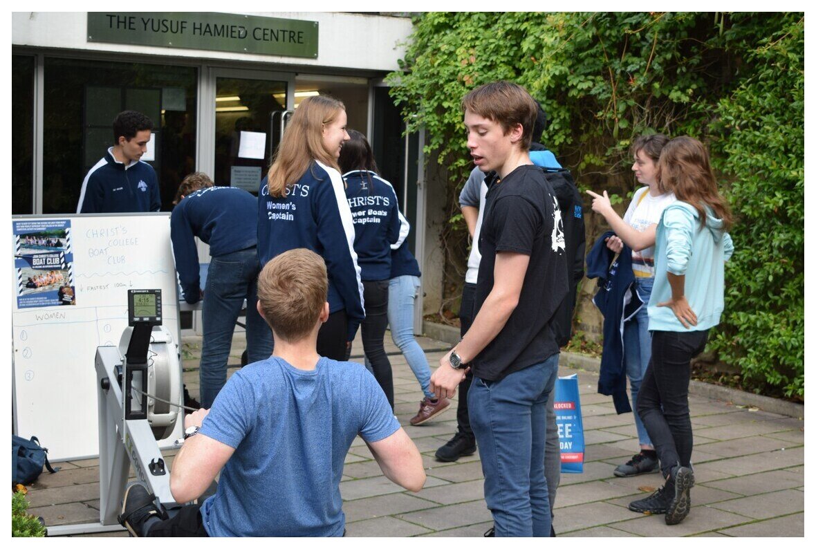 Students at Frershers fair including one trying a rowing machine