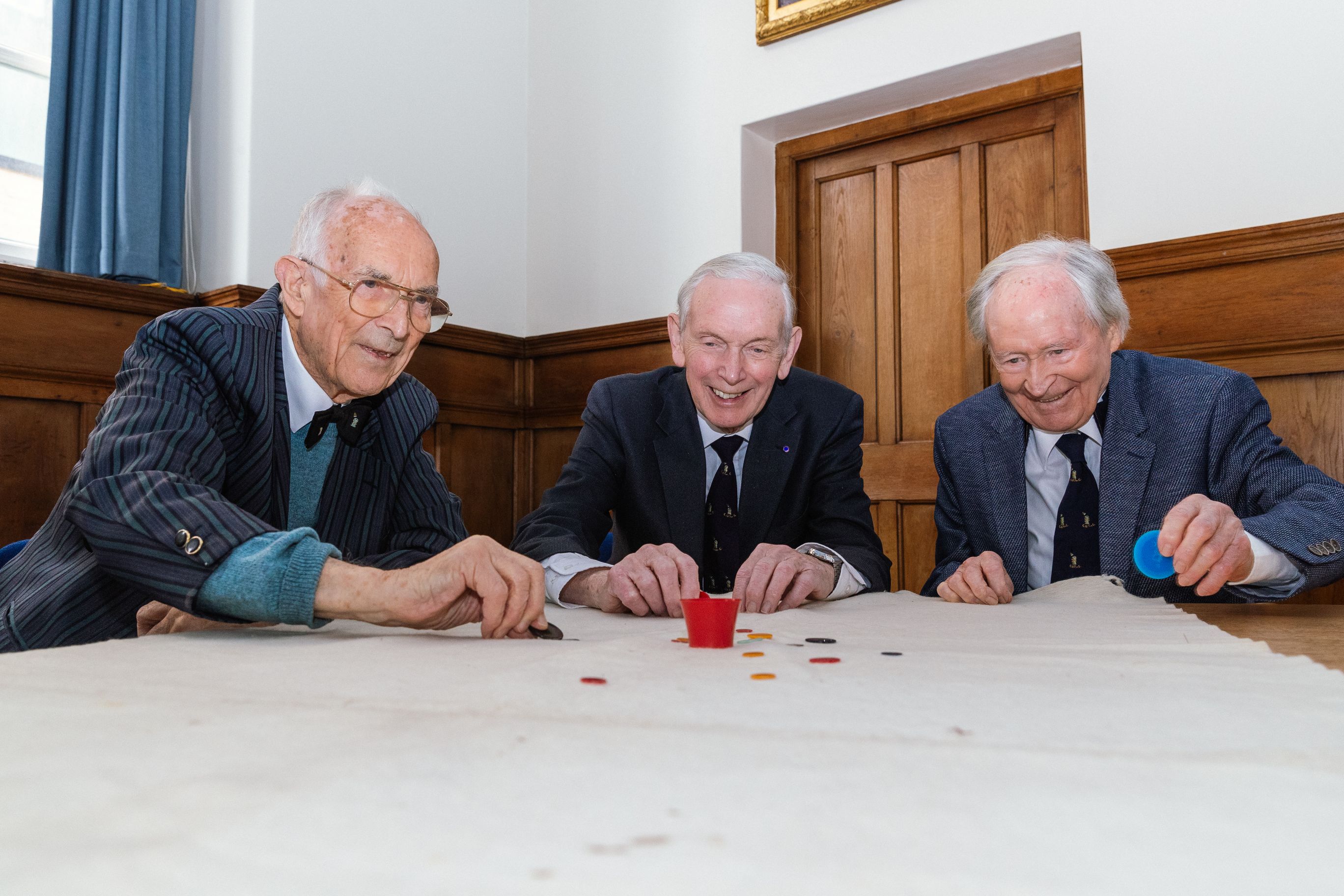 Three men playing tiddlywinks