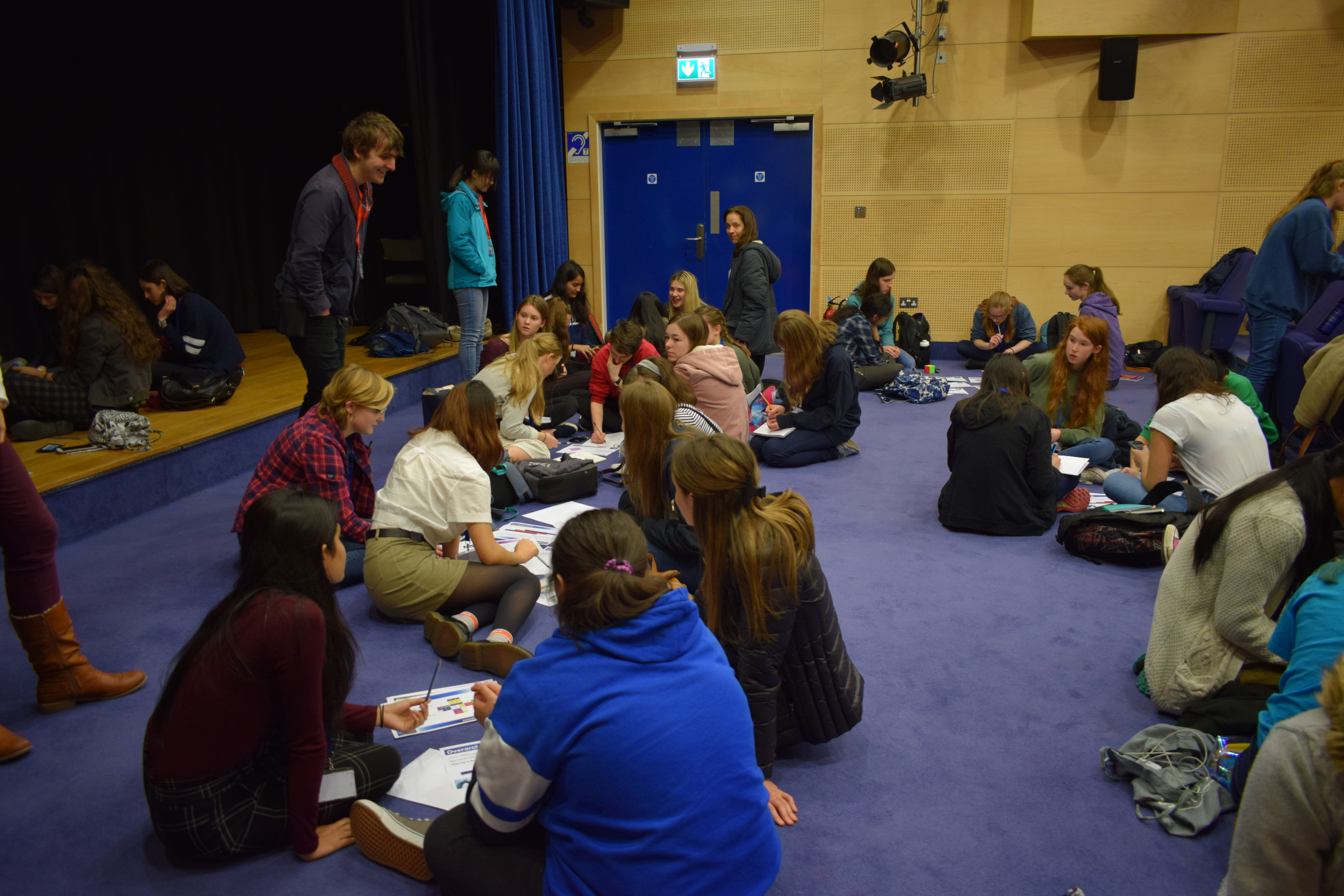 Students doing group work in the space in front of the stage