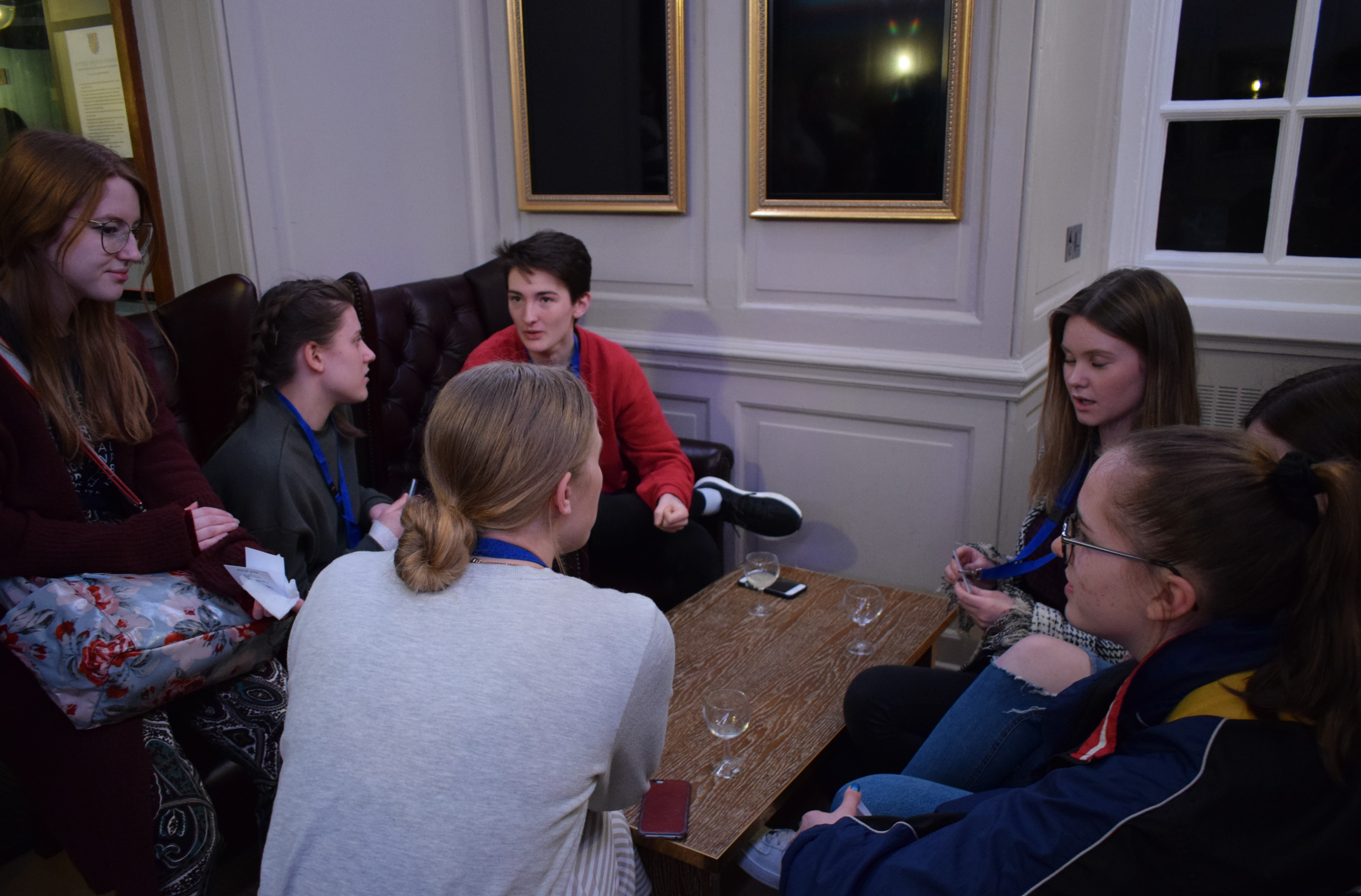 Small group on sofas around coffee table; chatting