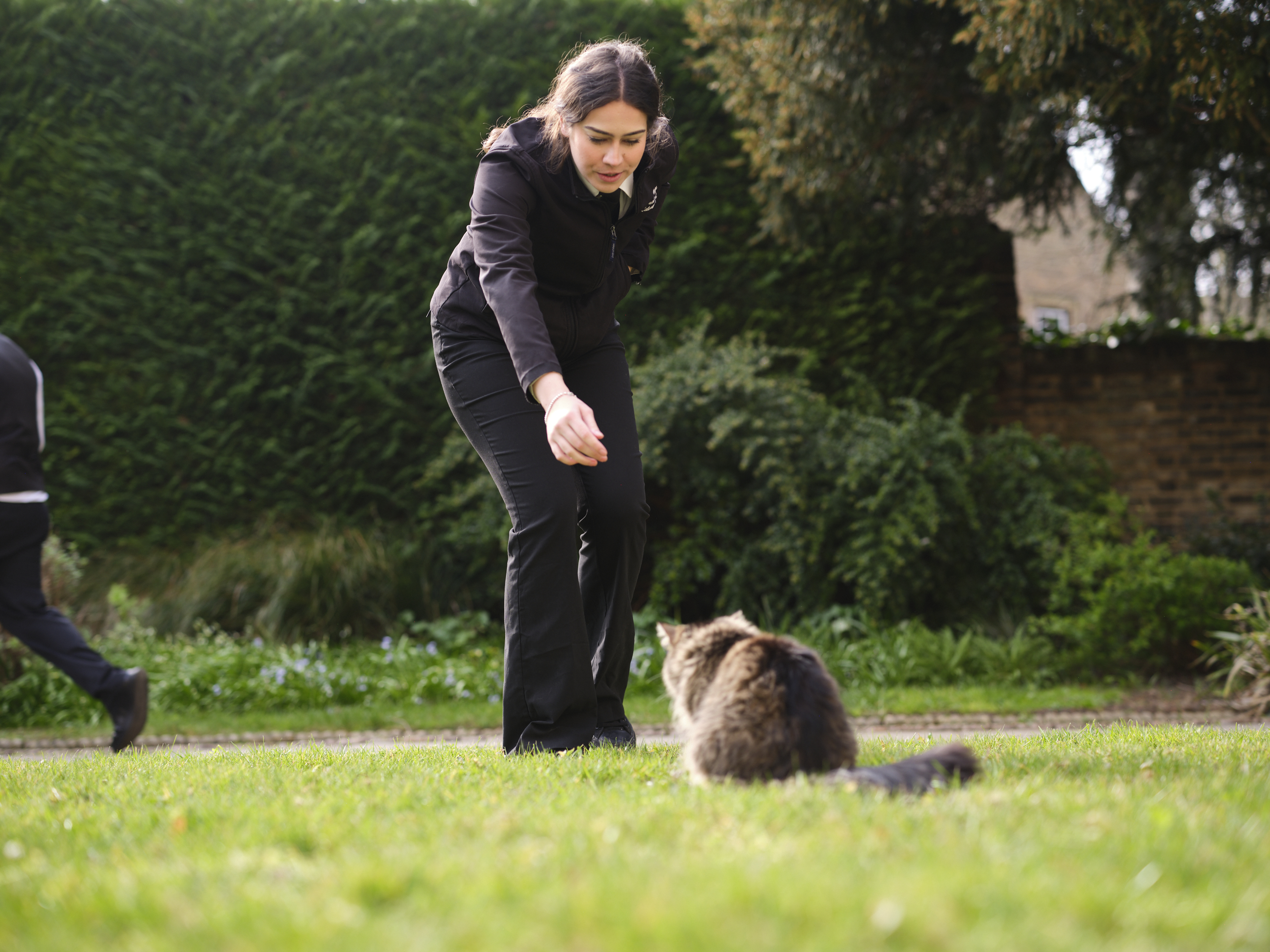 Staff member with Finch, one of the College cats