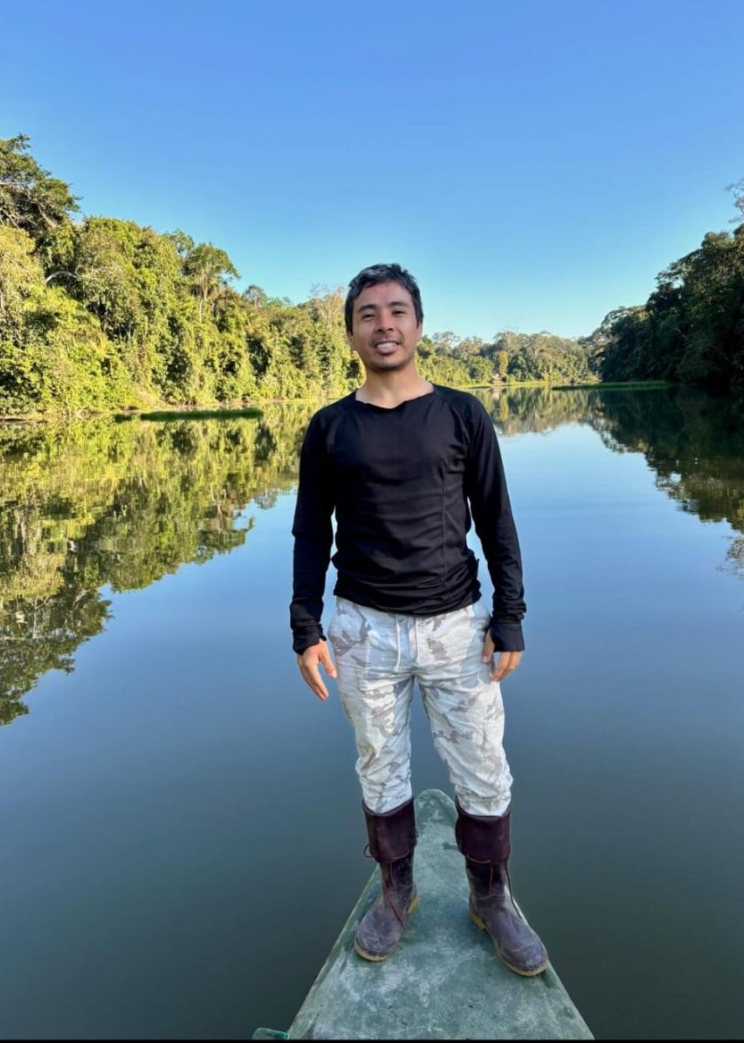 Parra Sanchez in the Amazon standing on the prow of a canoe