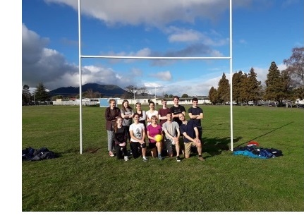 A mixed football team, posing for a photo inside the goal.