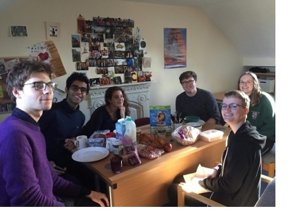 A group of students sitting around a table laden with breakfast food in a Jesus Lane house.