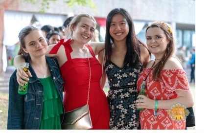 Four female students attending a garden party in Cambridge.
