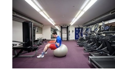 A male student using an exercise ball in the gym at Christ's College, Cambridge.