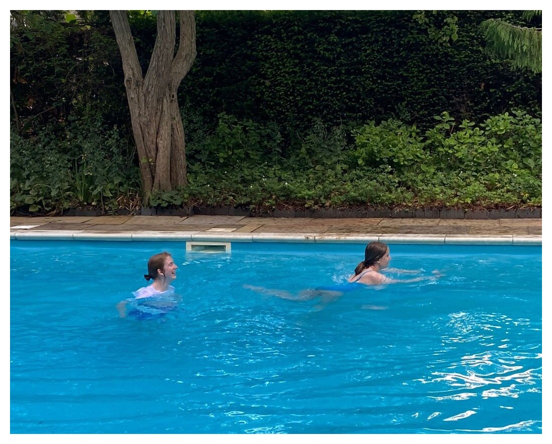 Two students swimming in a blue pool