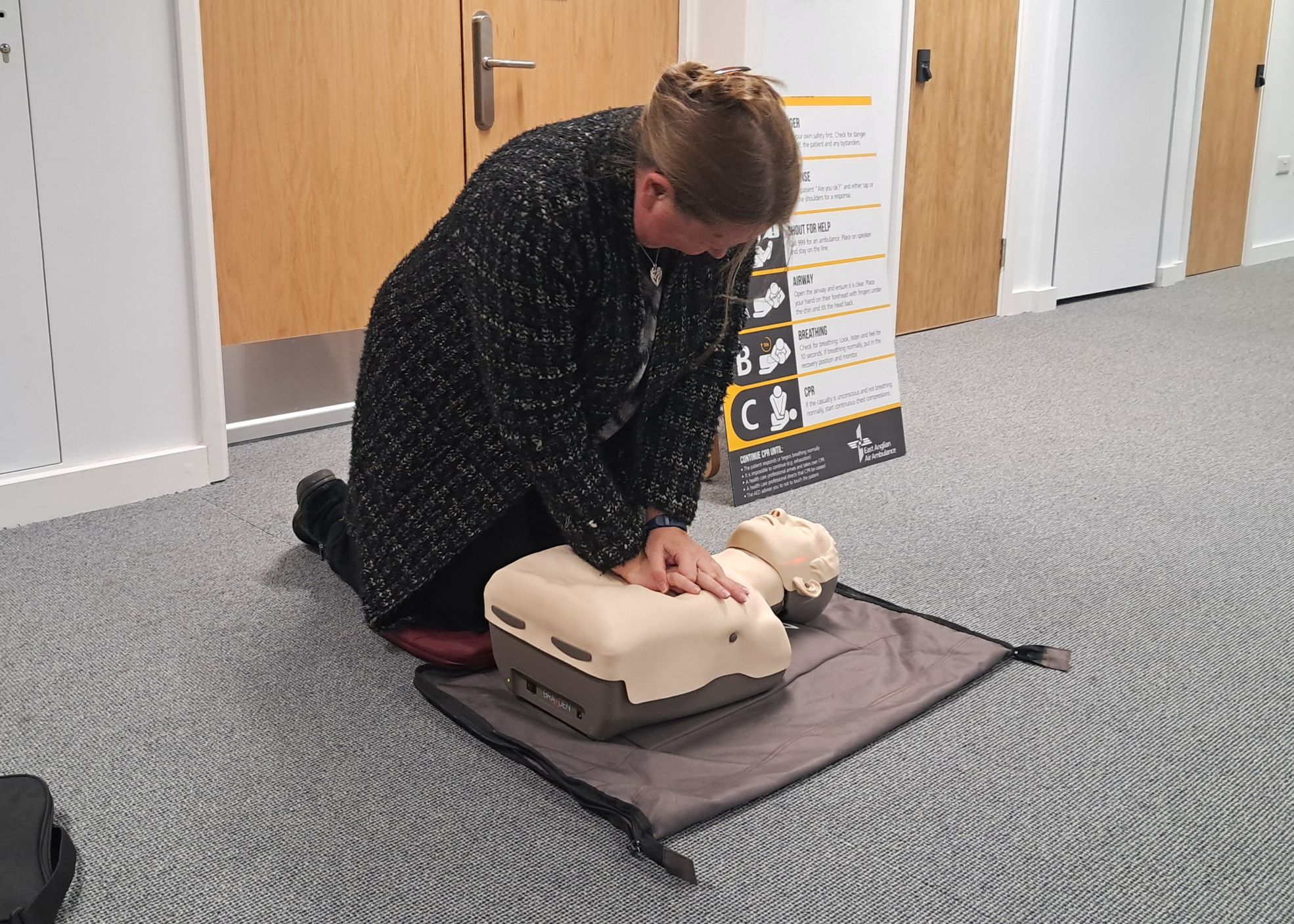 Person practising CPR using a dummy