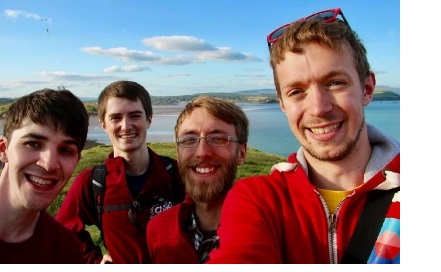 A selfie showing a group of men, all wearing red jackets.