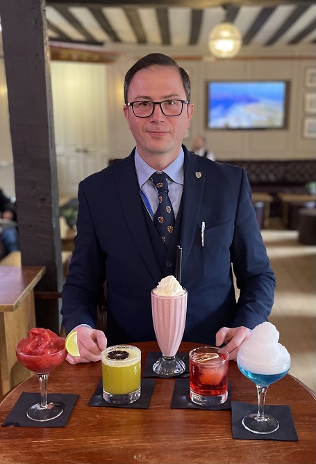 Kiril in the bar with five cocktails