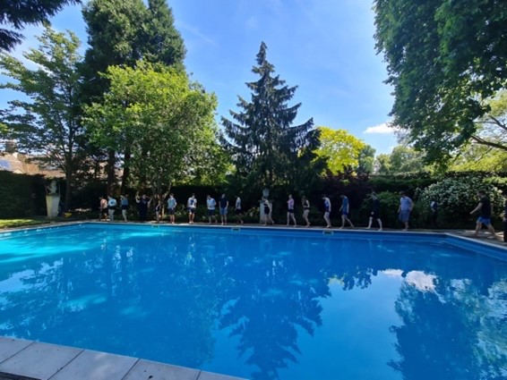 A line of students ready to jump into the College swimming pool