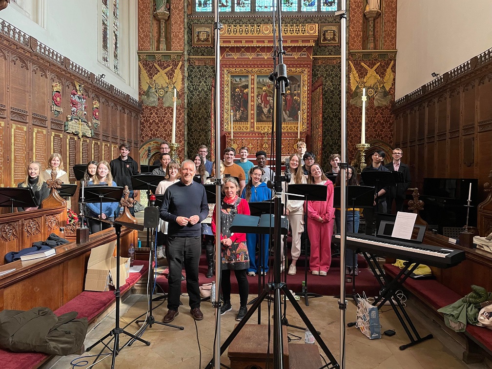 A large group of people in a chapel with music stands