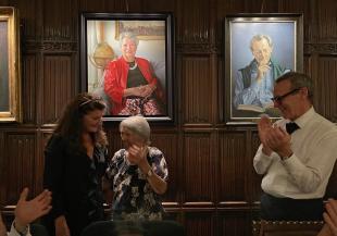 Three people in front the a portrait