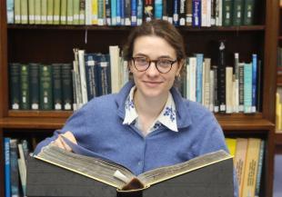 Charlotte with a book in a Library