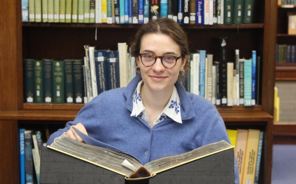 Charlotte with a book in a Library