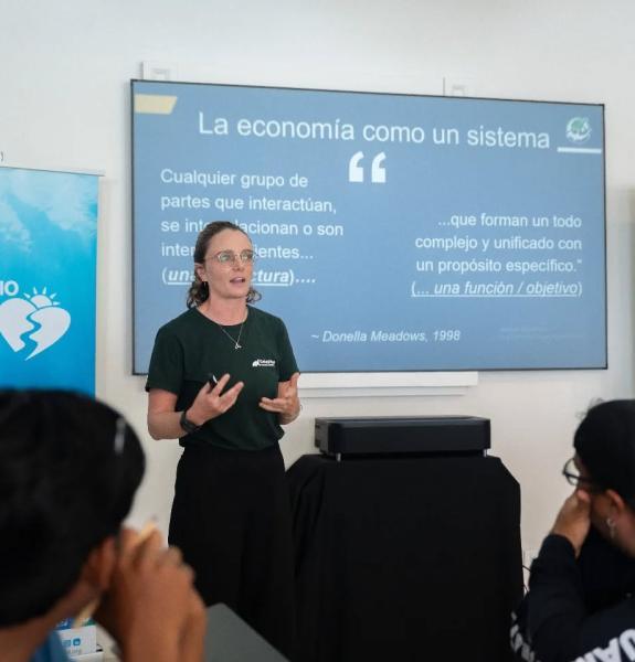 Chloe King speaking in front of information banners
