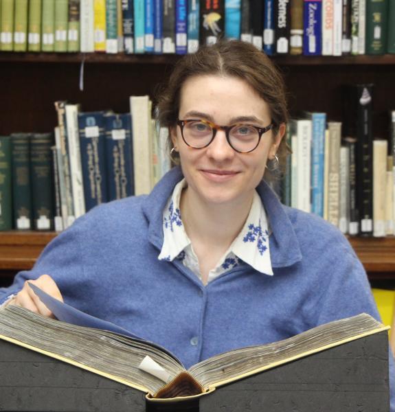 Charlotte with a book in a Library