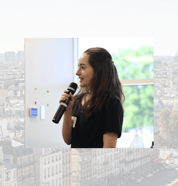 Headshot of Lea against a Paris rooftops background