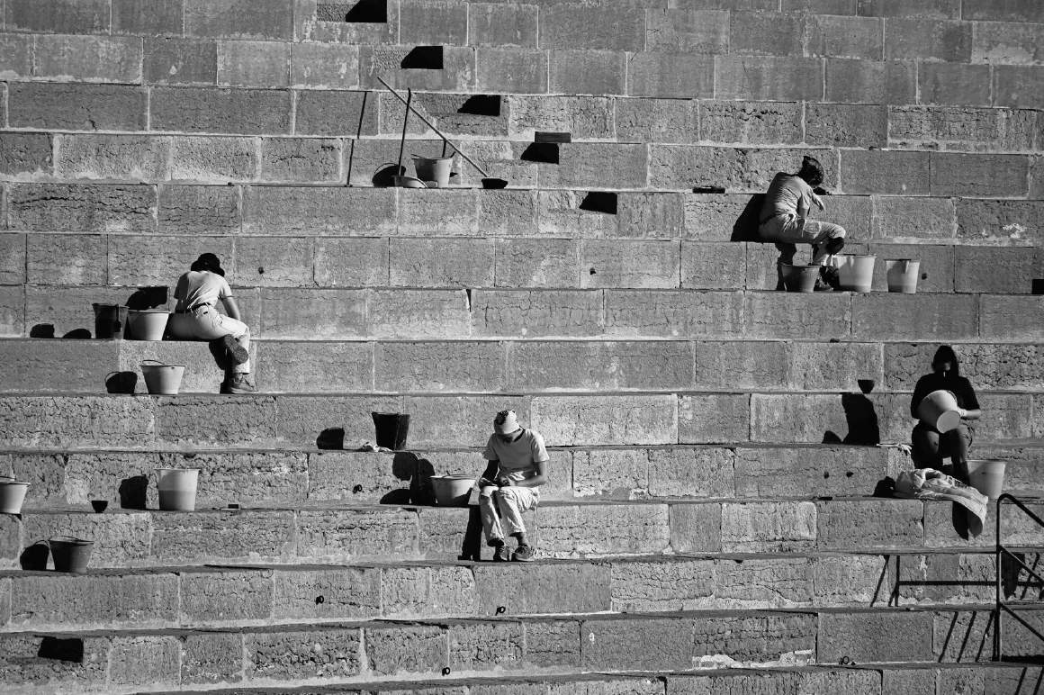 Photograph of people repairing an amphitheatre