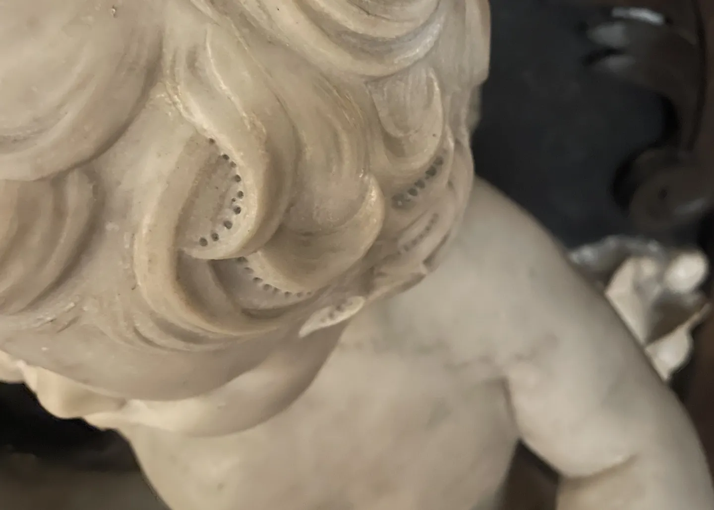 Detail of cherub with pilot holes on hair curls