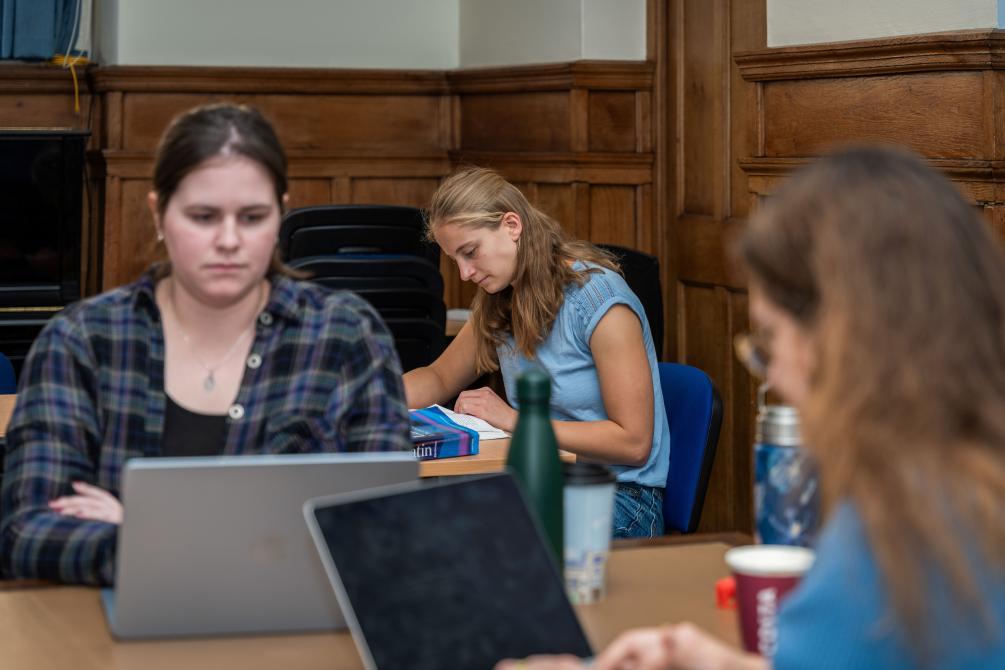 Three students working on laptops