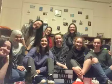 Belinda and a group of friends celebrating a birthday in a student room in Christ's College, Cambridge.