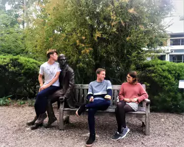 Clara and friends sat on a bench in the Charles Darwin sculpture garden in Christ's College, Cambridge.