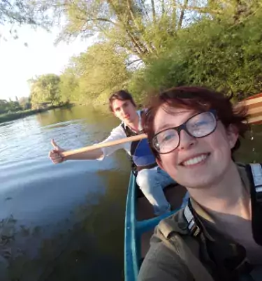 A selfie, taken by Olivia, of her and a friend paddling in a boat.