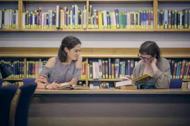 Two students at desks in library